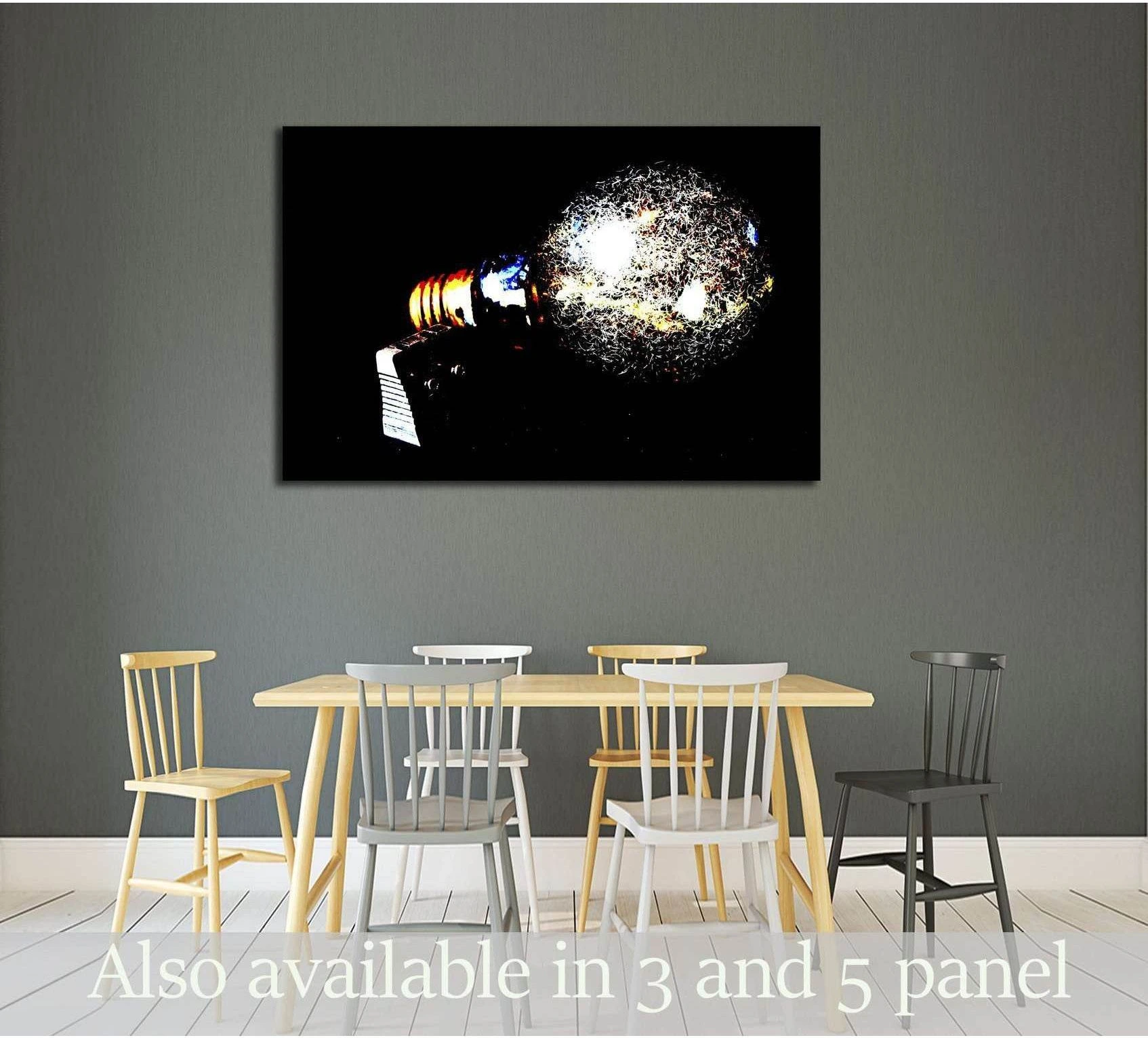 Glowing light bulb pop art canvas print on black background hung above a dining table in a modern room