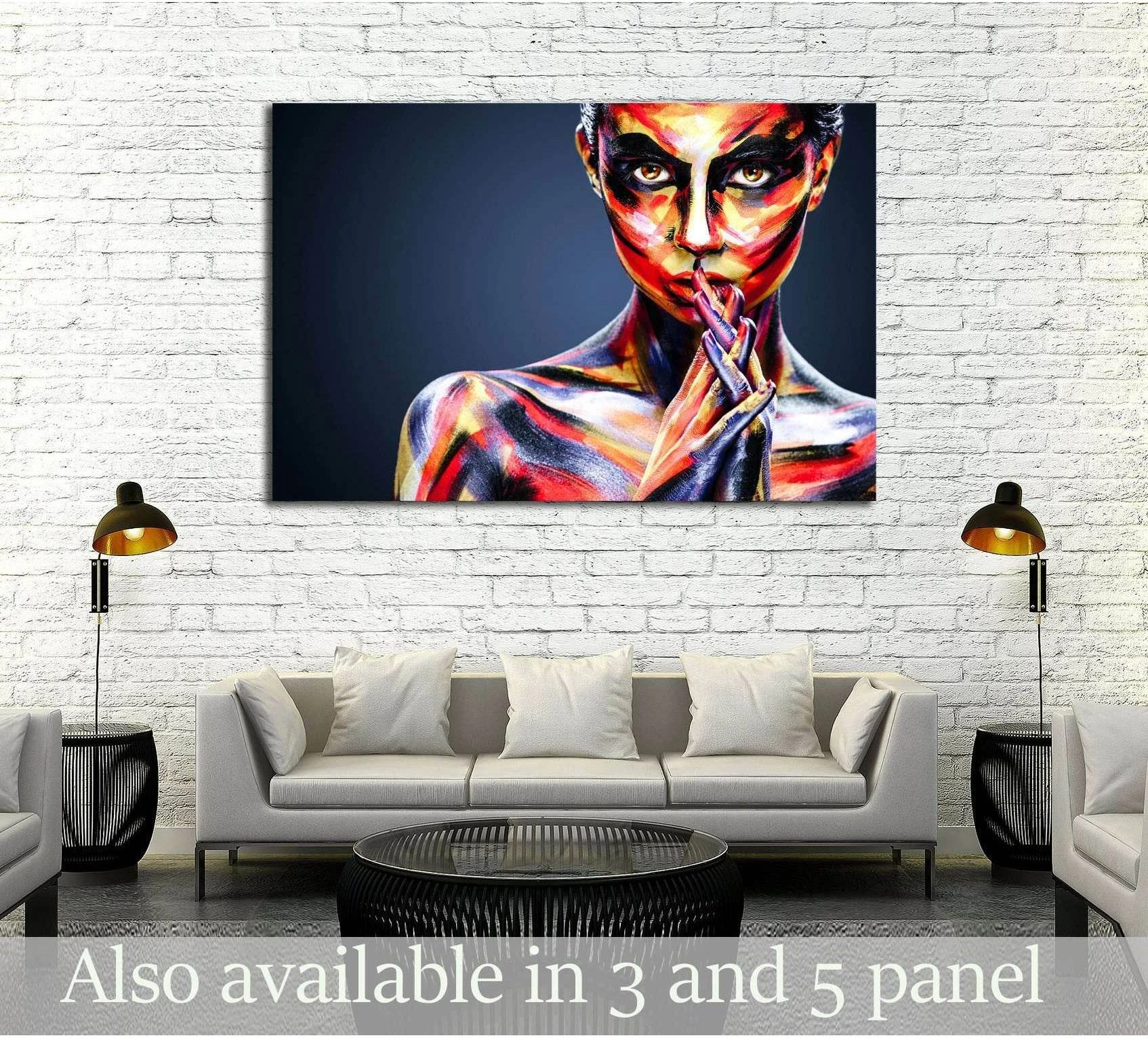 Colorful woman portrait canvas print with vivid face and body paint displayed above a sofa in a modern living room