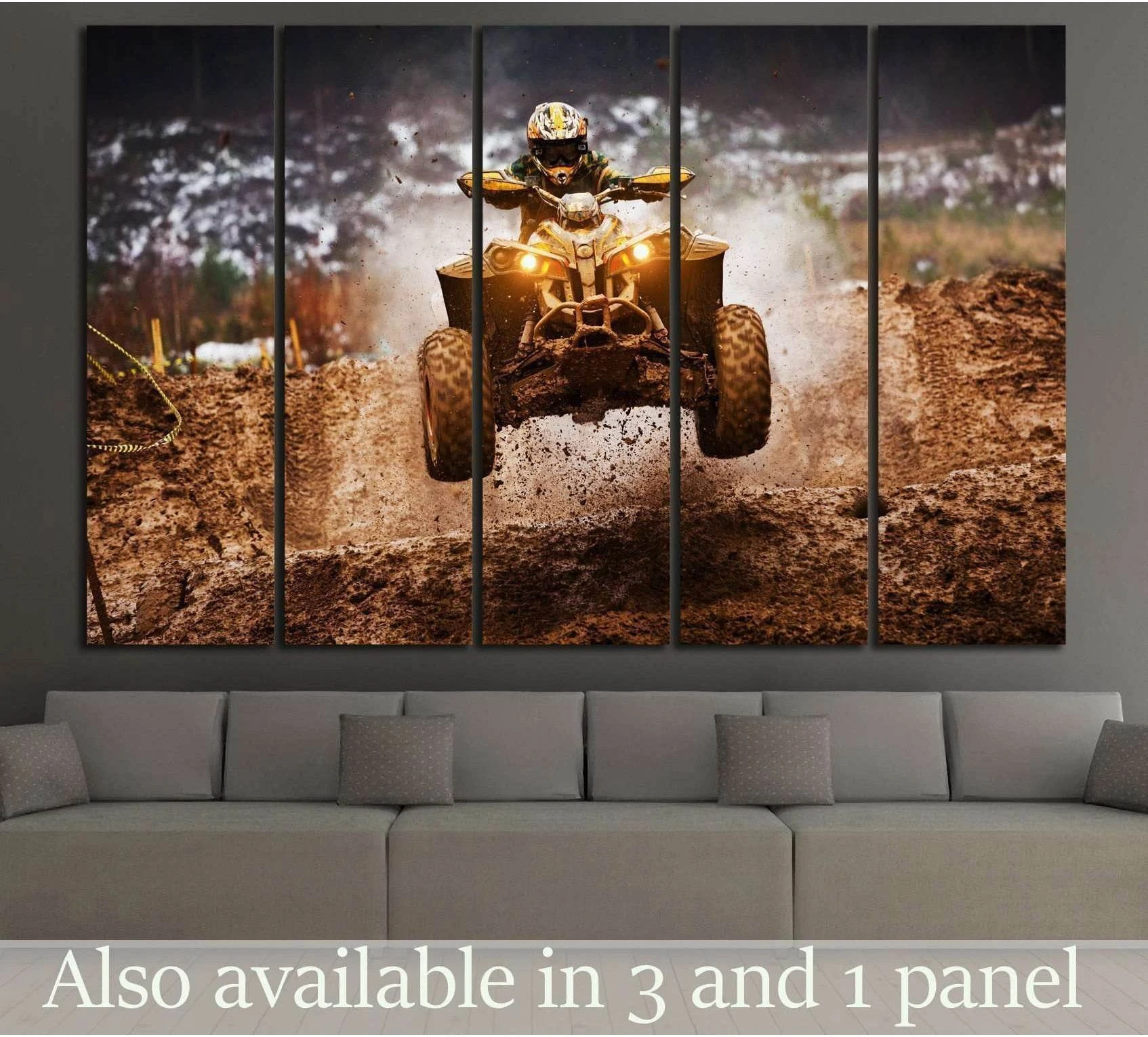 ATV quad canvas print with rider mid-jump through mud, hung above a sofa in a modern living room