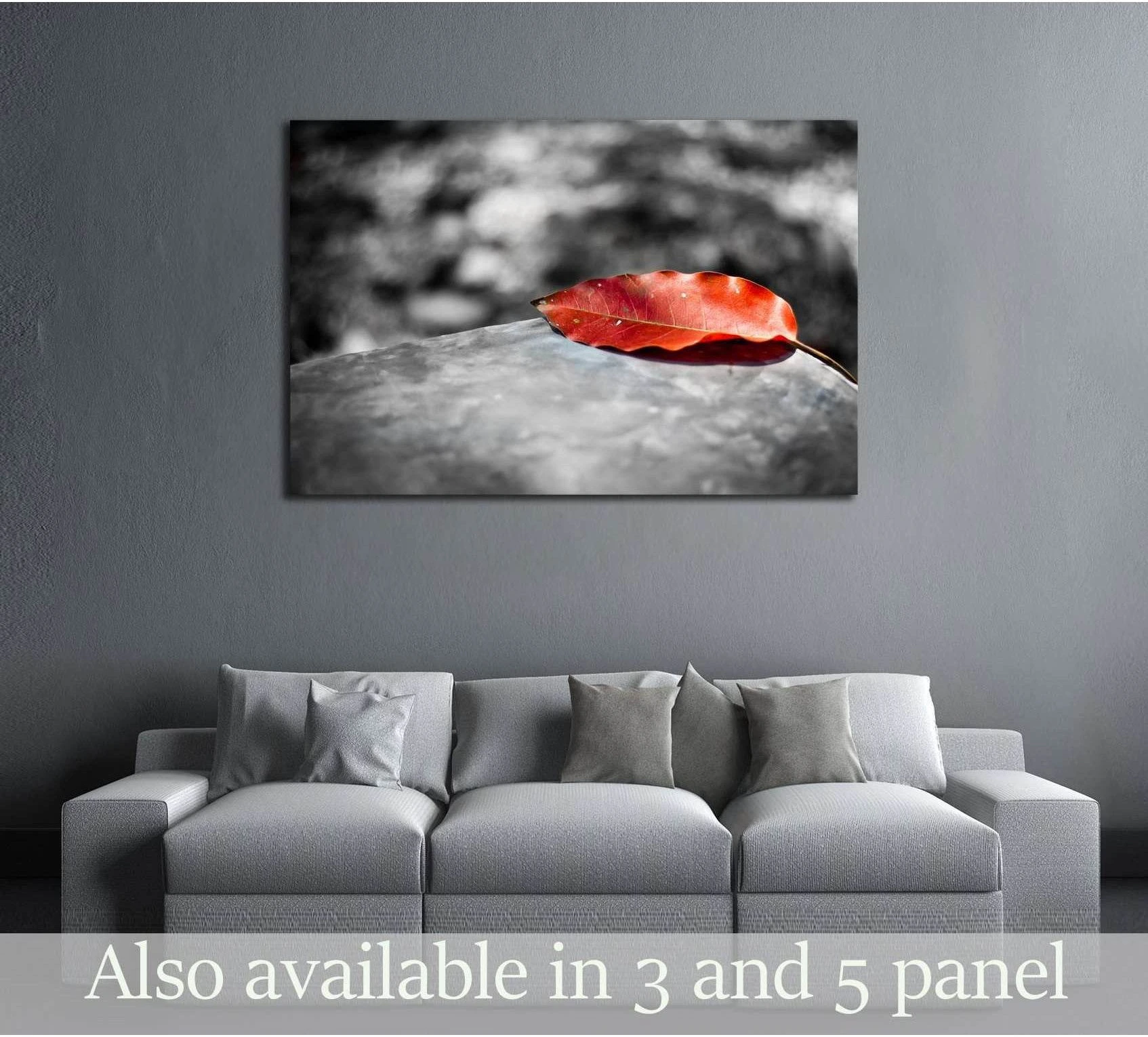 Red leaf canvas print on a black and white blurred background, displayed above a gray sofa