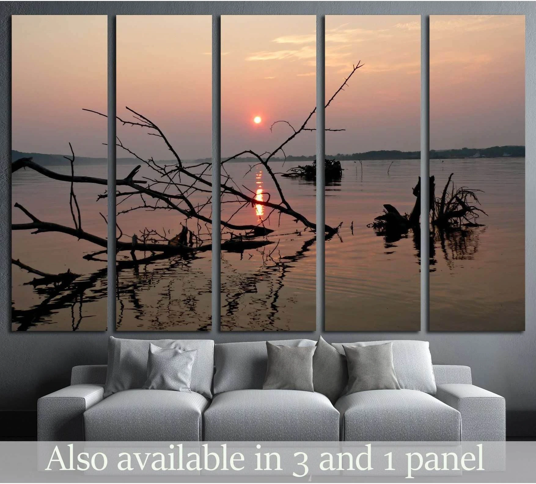 Sunset river canvas print with silhouetted driftwood above a sofa in a modern living room