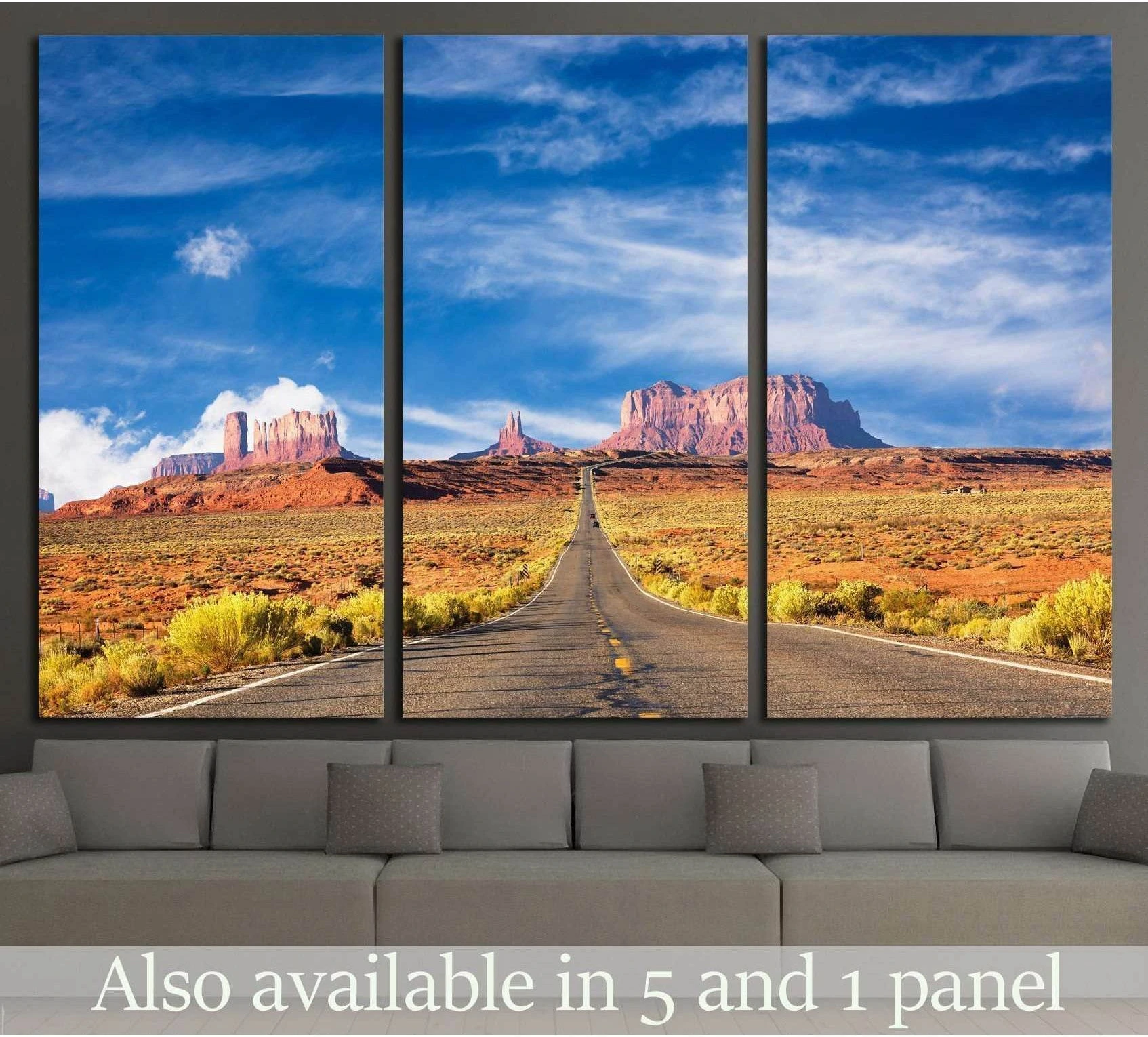Monument Valley road triptych canvas print above a sofa with desert highway, red rock buttes, and blue sky