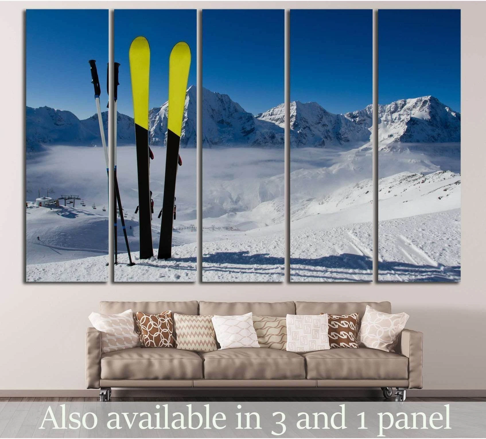 Yellow skis in fresh snow with alpine mountain peaks canvas print hung above a sofa in a modern living room