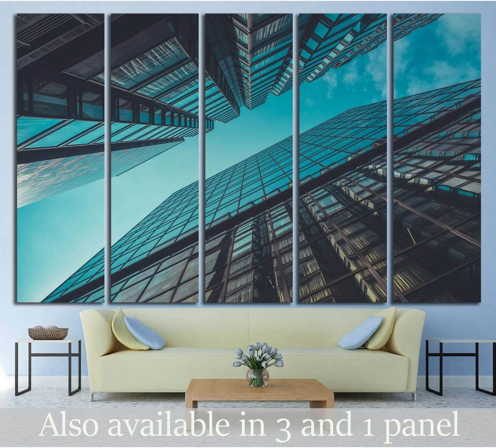Upward view of glass skyscrapers against a teal sky canvas print above a sofa in a modern living room