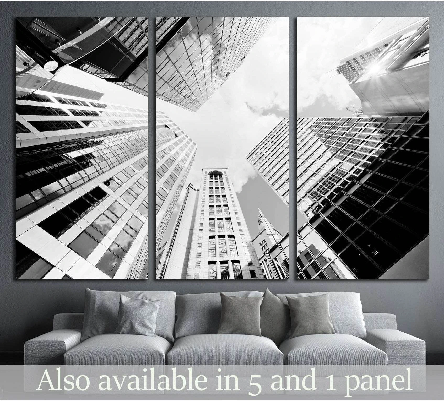 Black and white skyscraper triptych canvas print above sofa in a modern gray living room