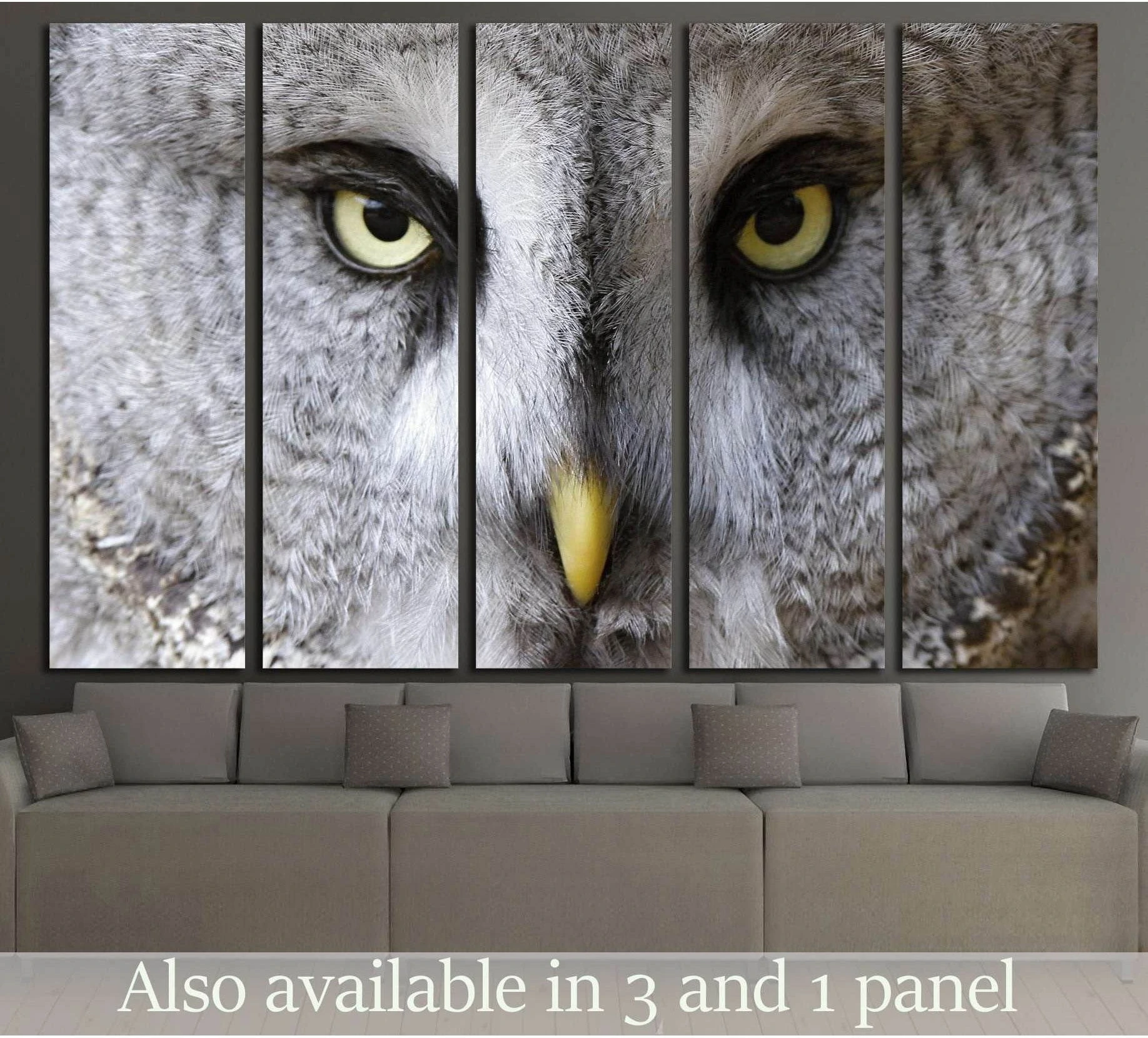 Close-up great grey owl canvas print with yellow eyes displayed above a sofa in a modern living room
