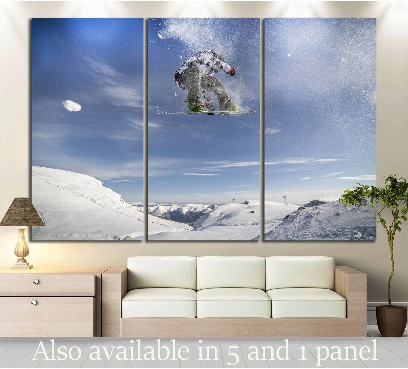 Snowboarder canvas print with rider mid-jump over snowy alpine mountains in a triptych living room display