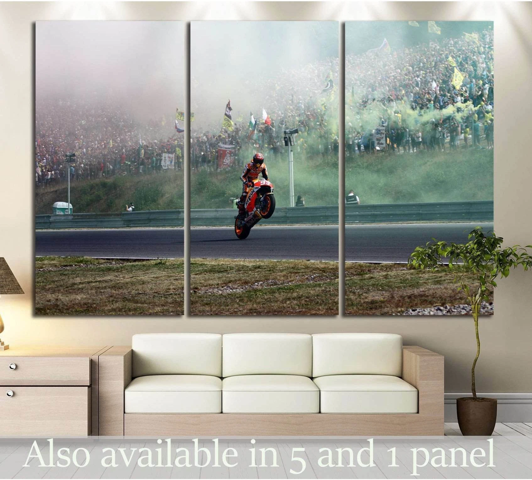 Red sportbike canvas print with rider doing a wheelie on a racetrack, displayed above a sofa in a modern living room