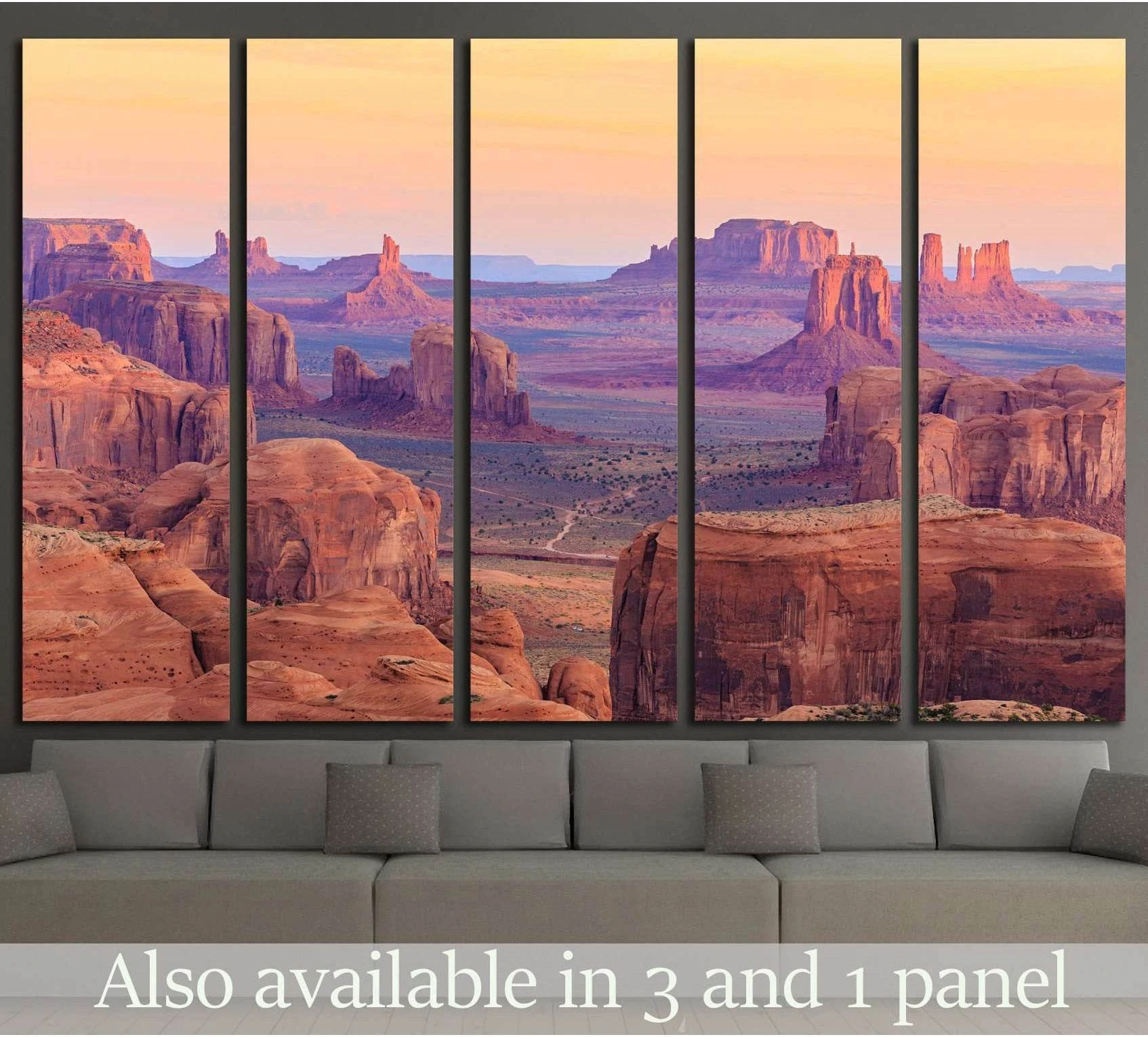 Monument Valley sunrise canvas print in warm desert tones above a sofa in a modern living room