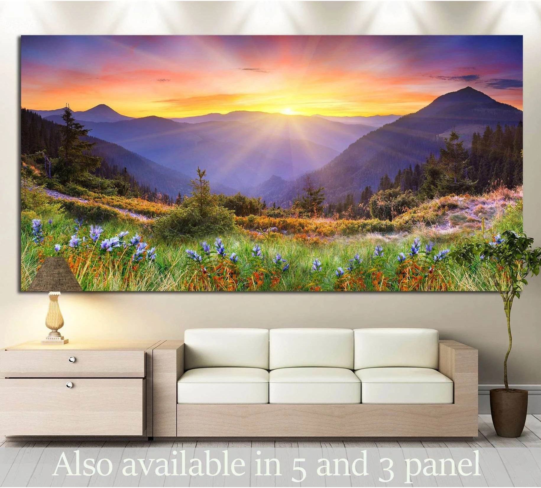 Mountain sunset canvas print with alpine wildflowers and layered peaks above a sofa in a modern living room