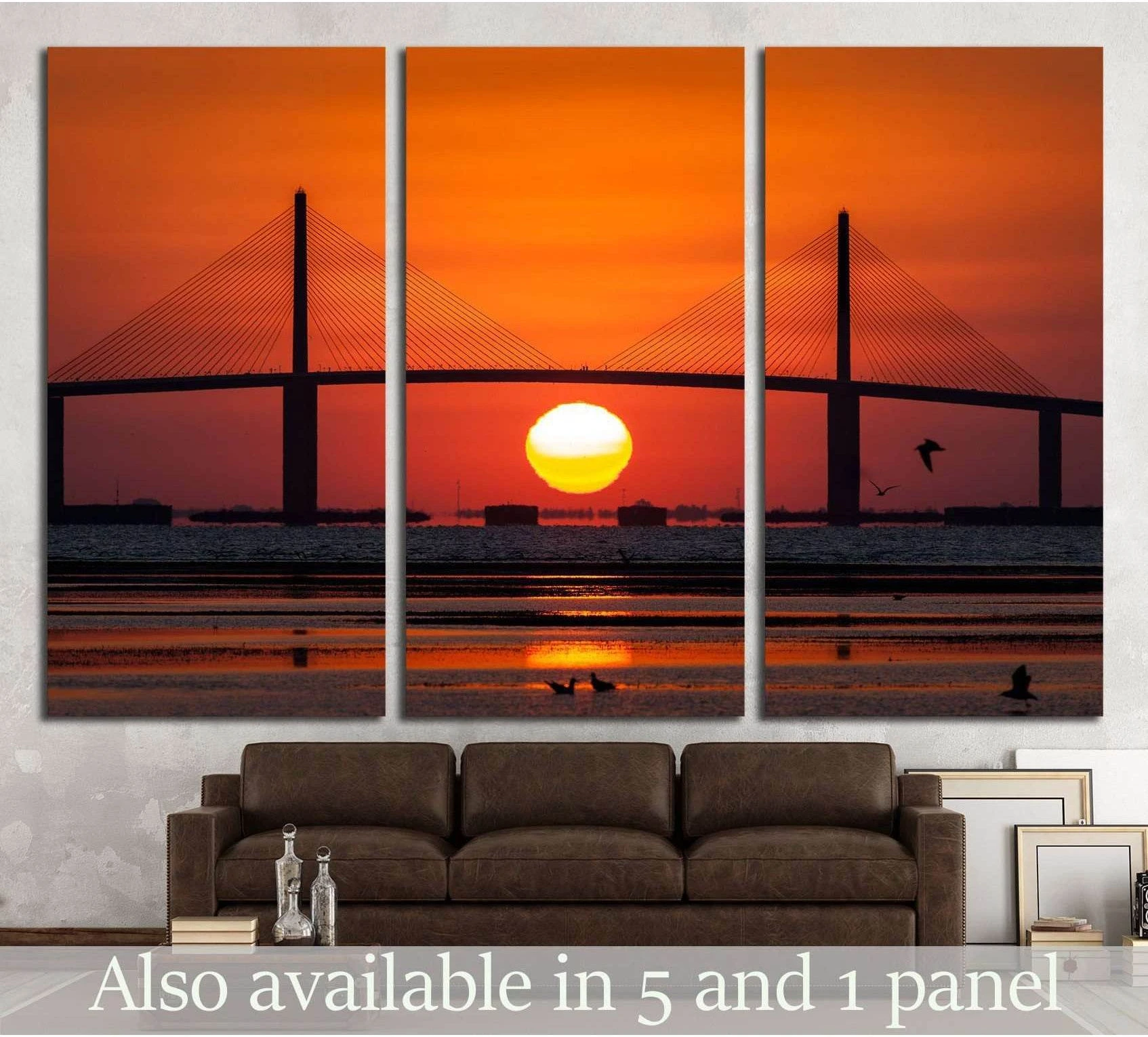 Sunshine Skyway Bridge canvas print with orange sunrise over Tampa Bay, shown as a triptych above a sofa