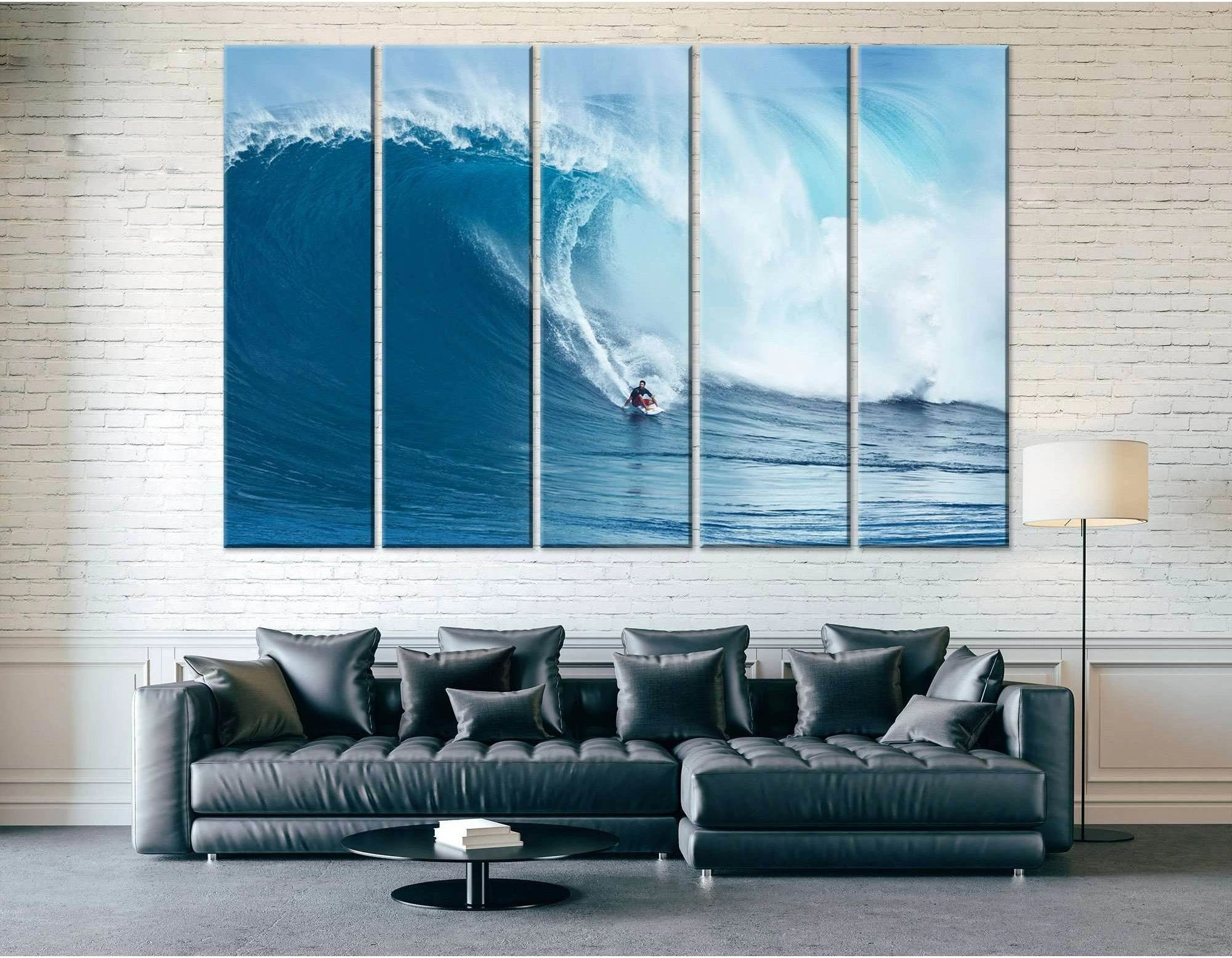 Big wave surfing canvas print with surfer under a curling blue wave above a sofa in a modern living room