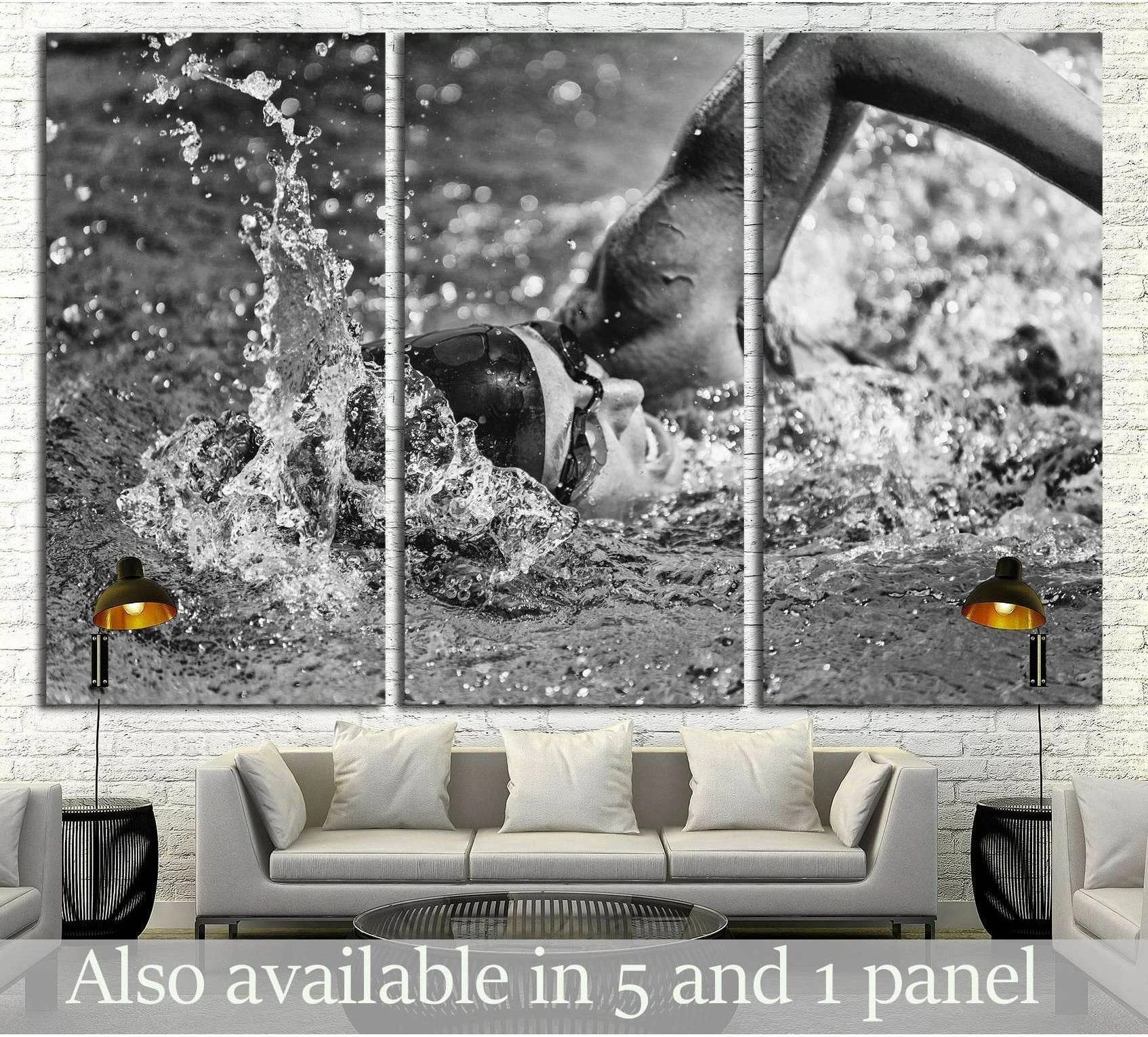 Black and white freestyle swimmer canvas print with dramatic water splash, shown as triptych above a sofa