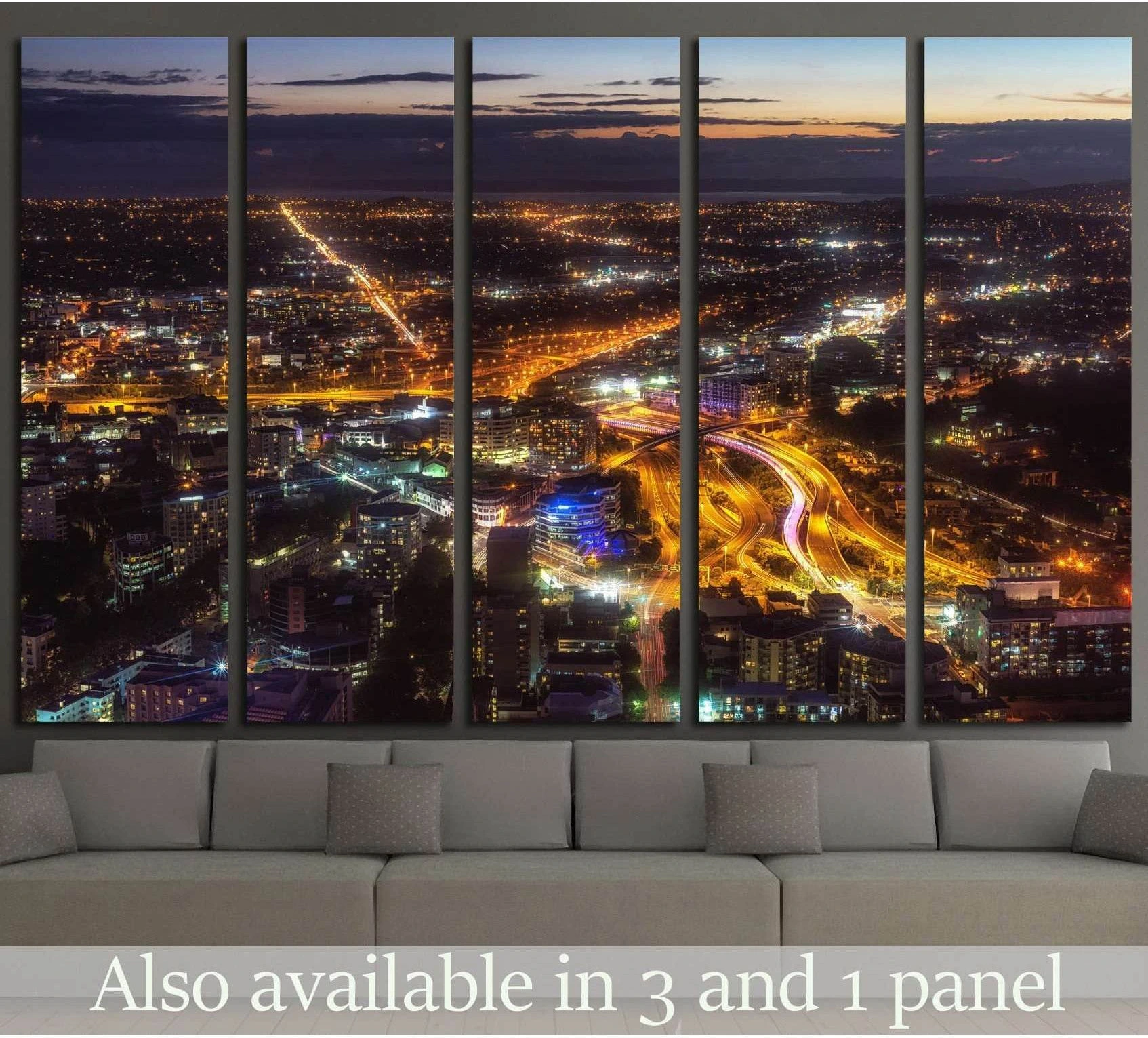 Auckland skyline canvas print with glowing night roads hung above a sofa in a modern living room