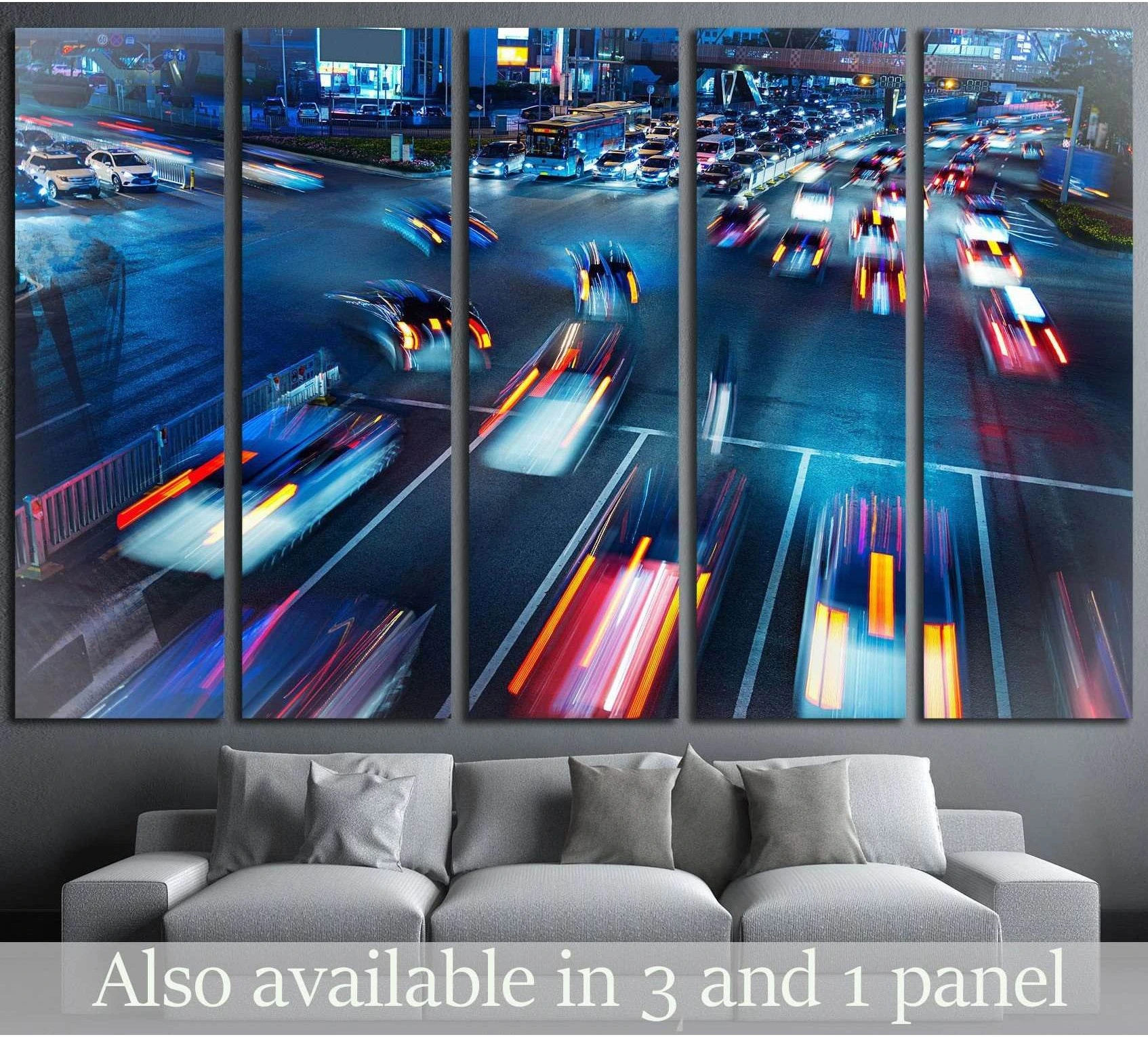 Night city traffic canvas print with blue long-exposure light trails above a sofa in a modern living room
