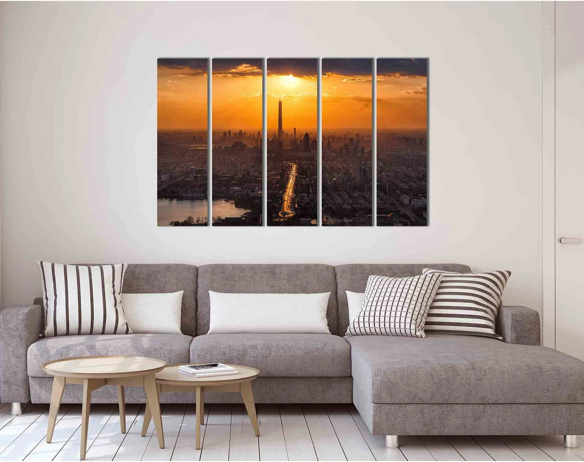 Sunset city skyline with a tall tower, glowing golden sun, and river reflections at dusk detail view
