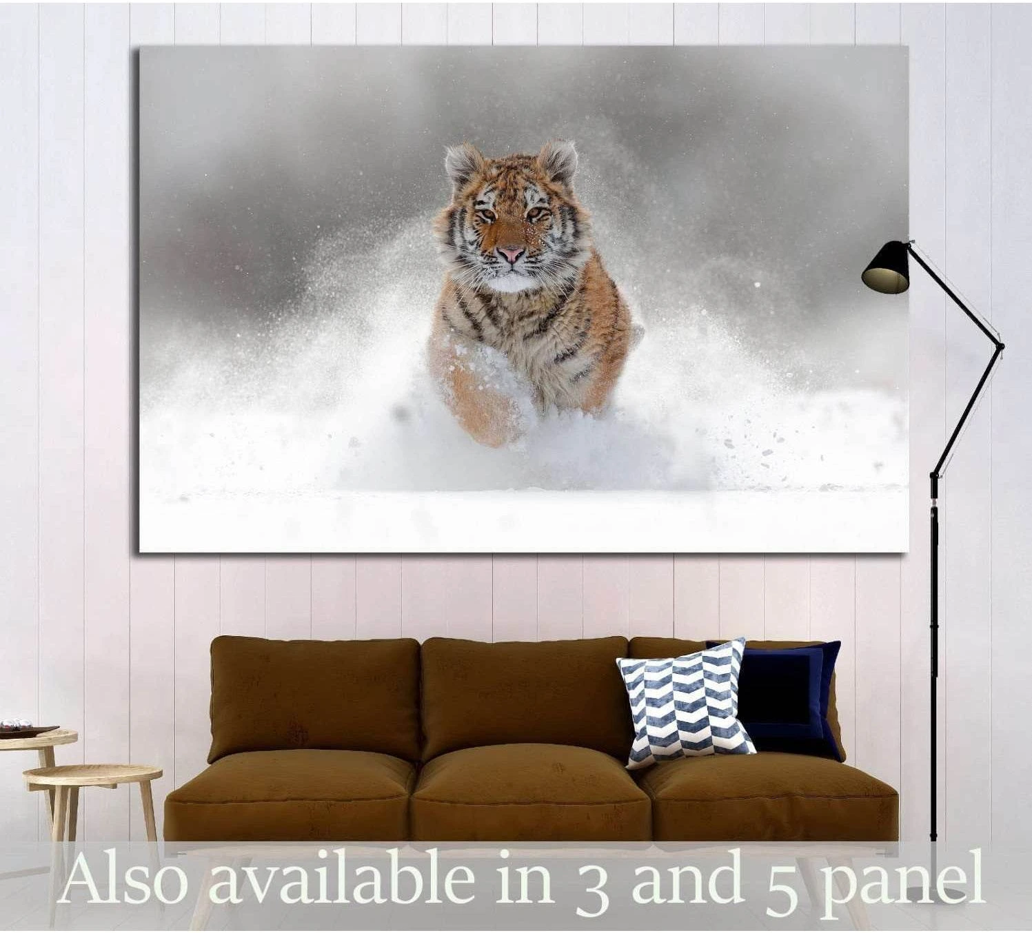 Amur tiger canvas print of a tiger running through deep snow, hung above a sofa in a modern living room