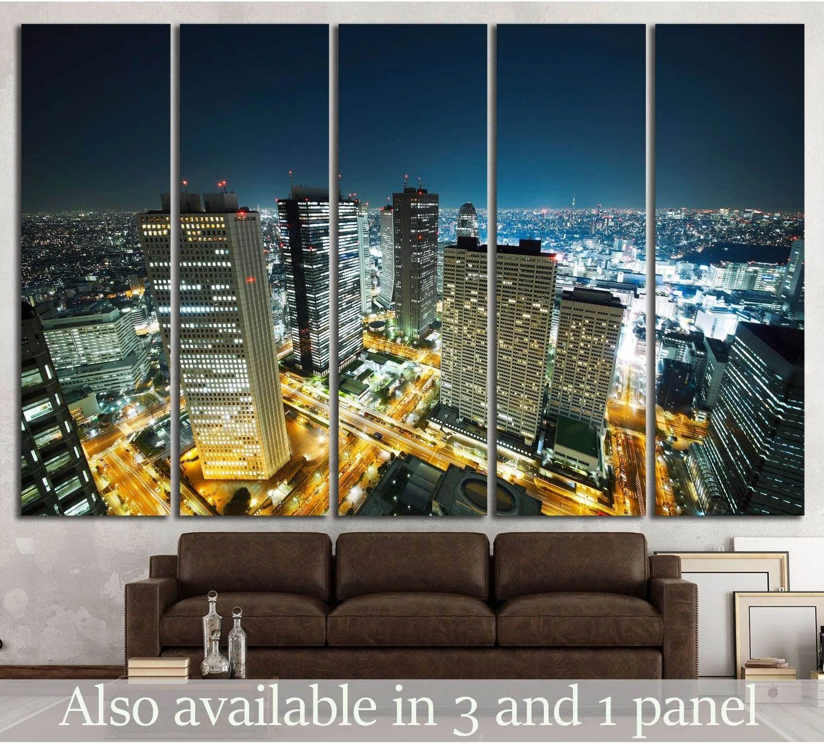 Tokyo skyline canvas print with glowing night city lights, displayed above a brown sofa