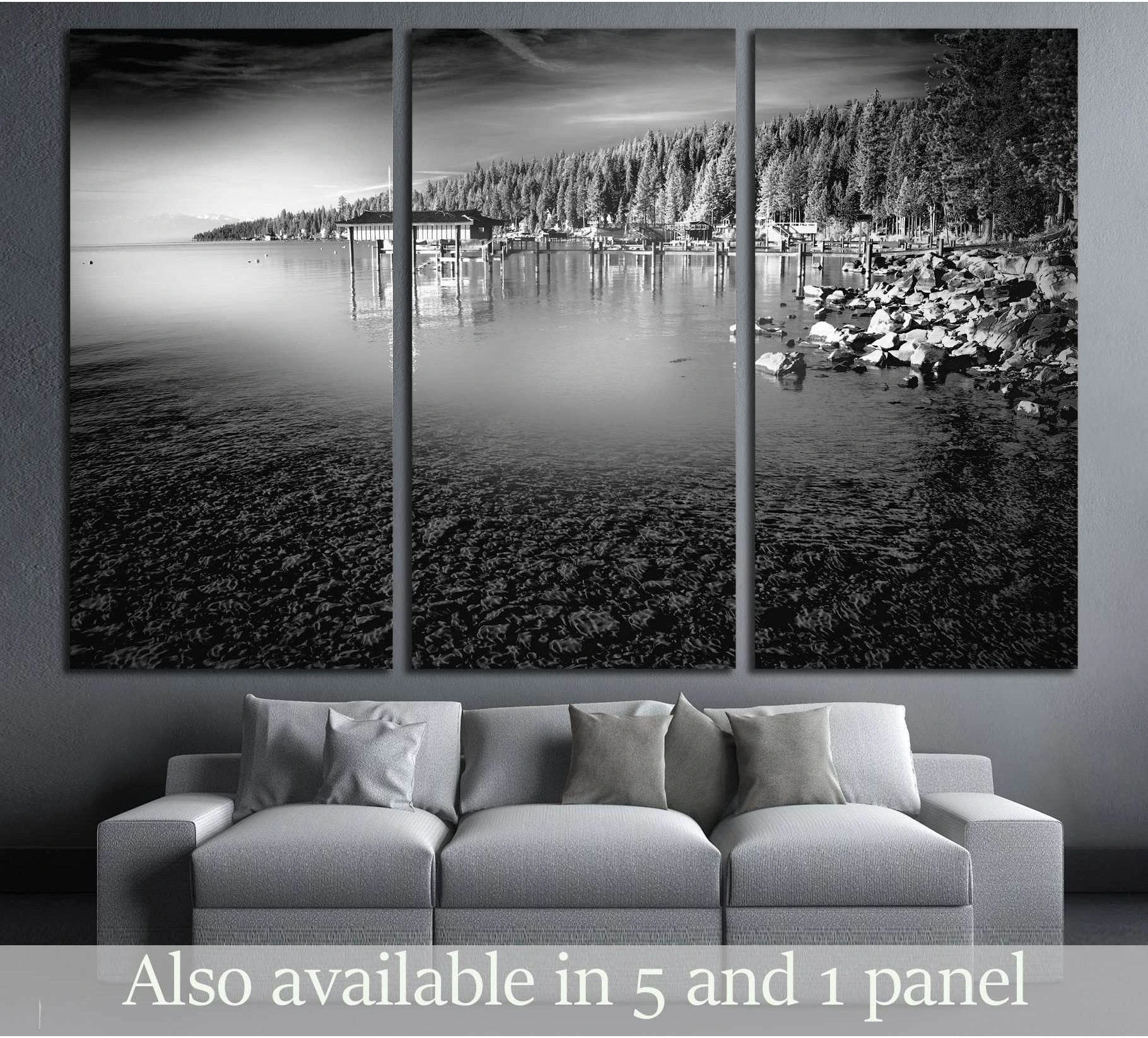 Black and white Lake Tahoe canvas print with pine shoreline and calm water shown as a triptych above a sofa