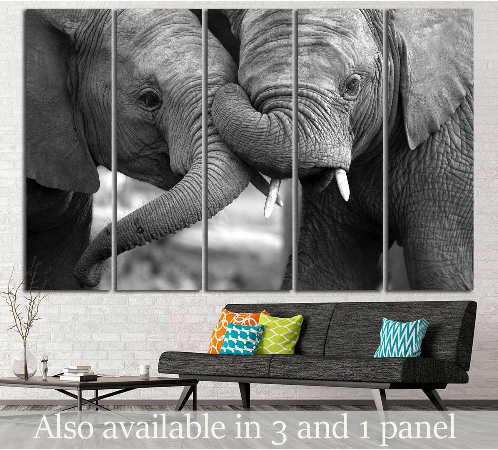 Black and white two elephants canvas print with touching trunks displayed above a sofa in a modern living room