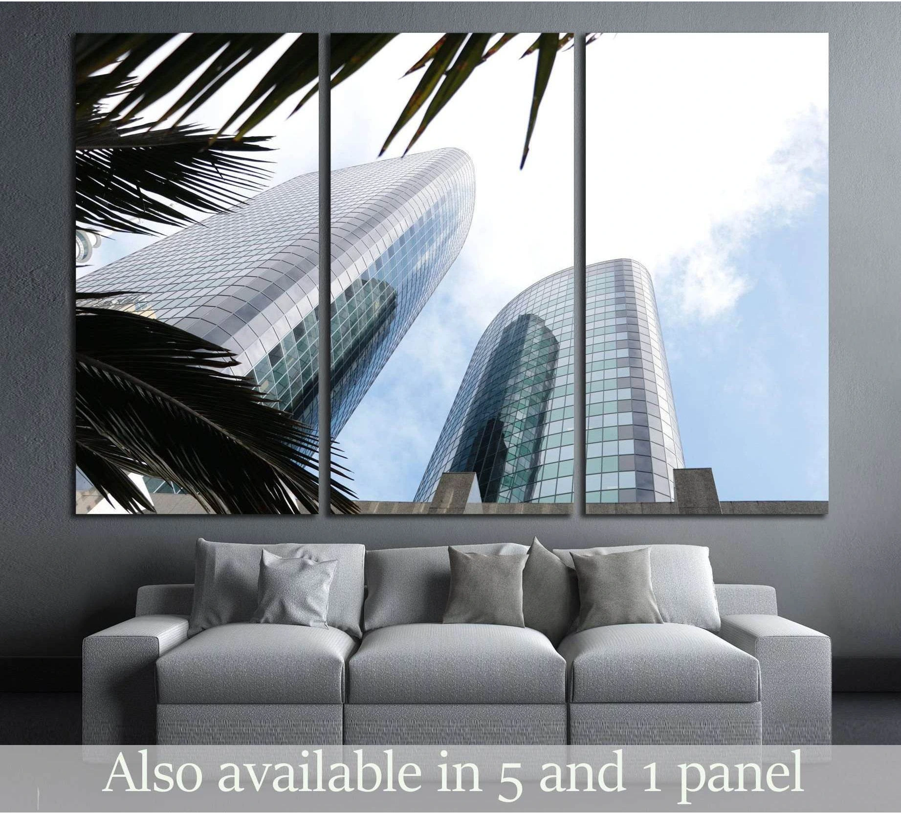 Blue glass skyscraper canvas print with palm fronds, shown above sofa in a modern living room