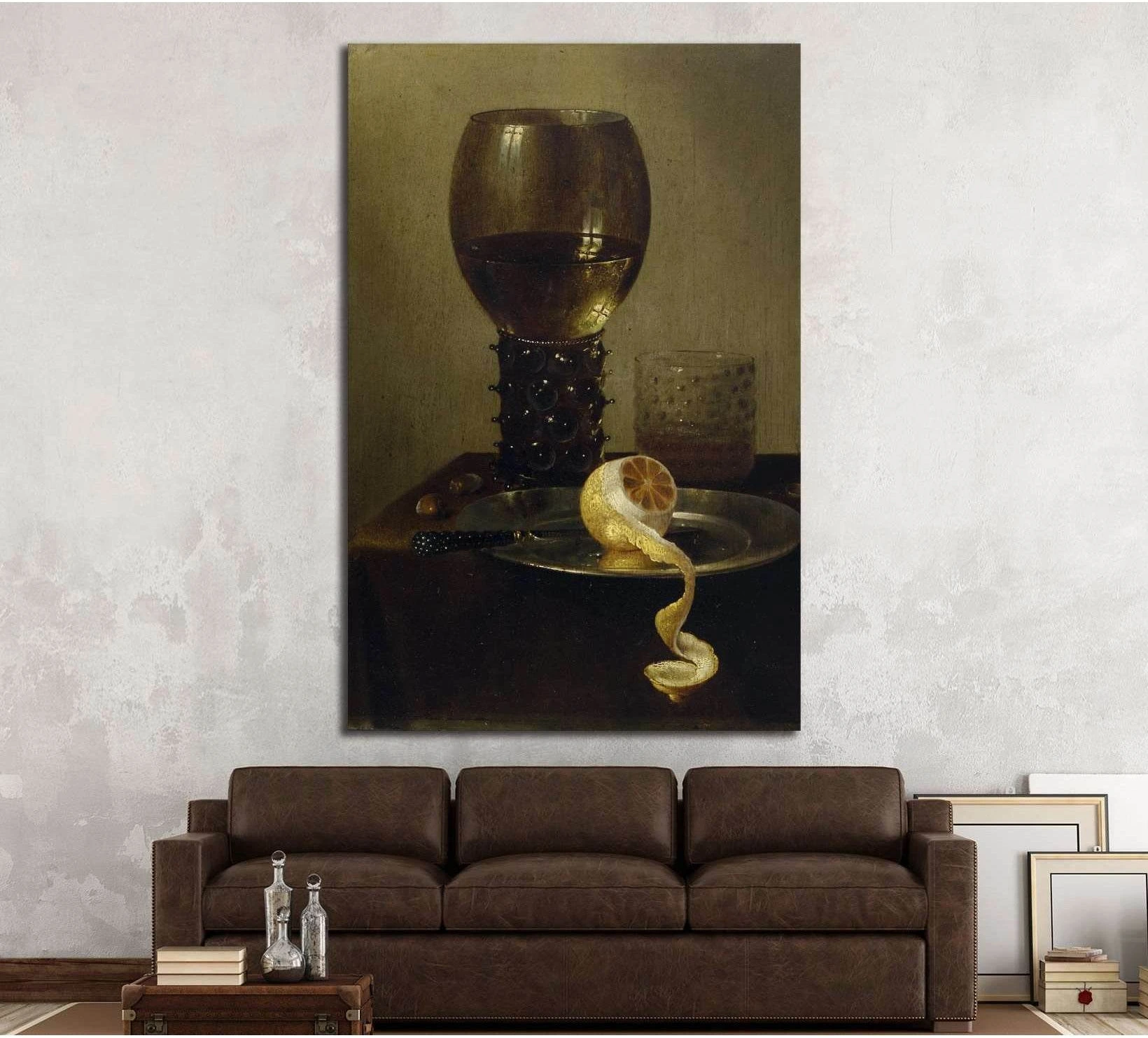 Wine glass and peeled lemon still life canvas print hung above a brown sofa in a neutral living room