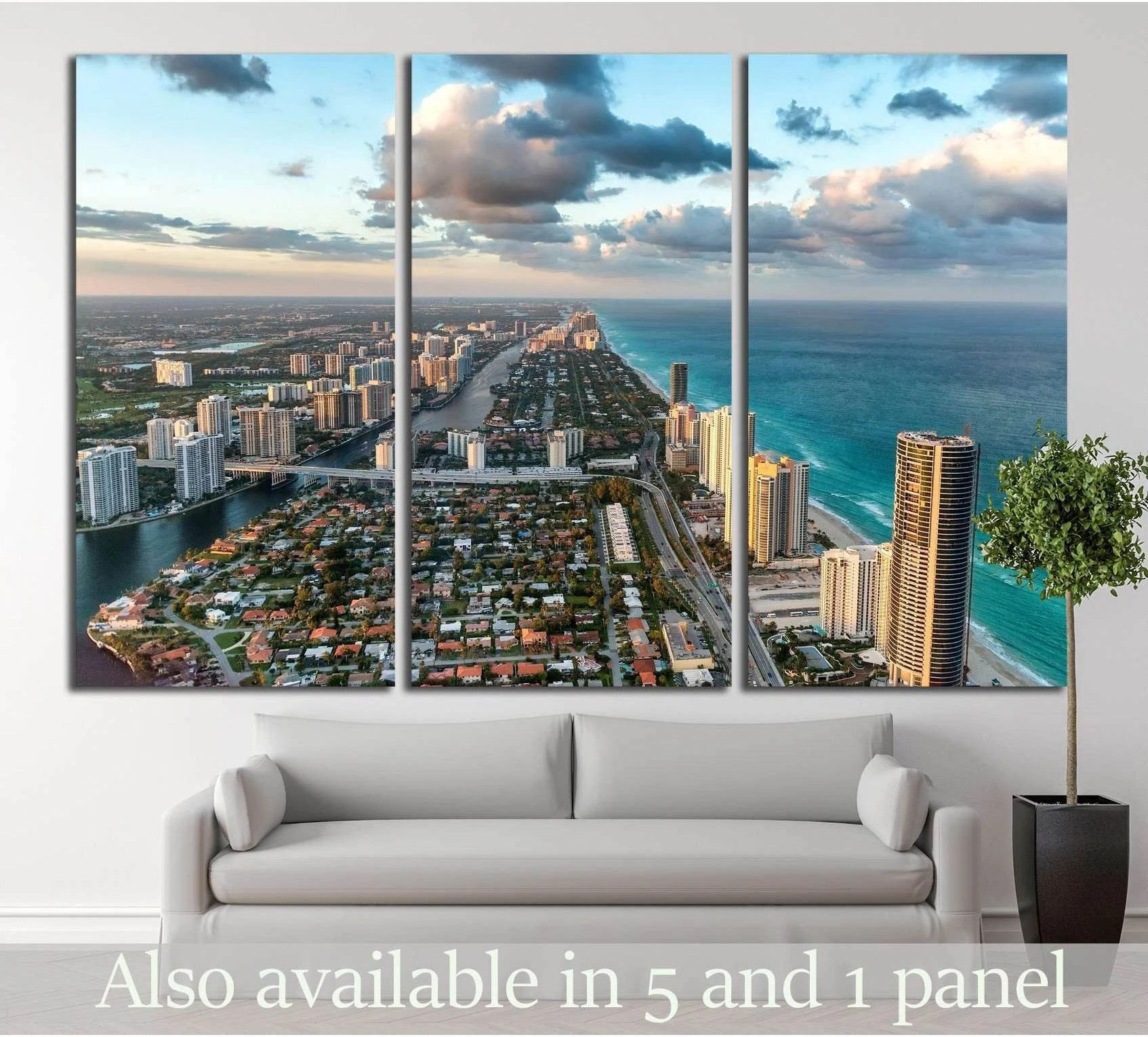 Aerial Miami skyline triptych canvas print with turquoise ocean and sunset clouds above a modern sofa
