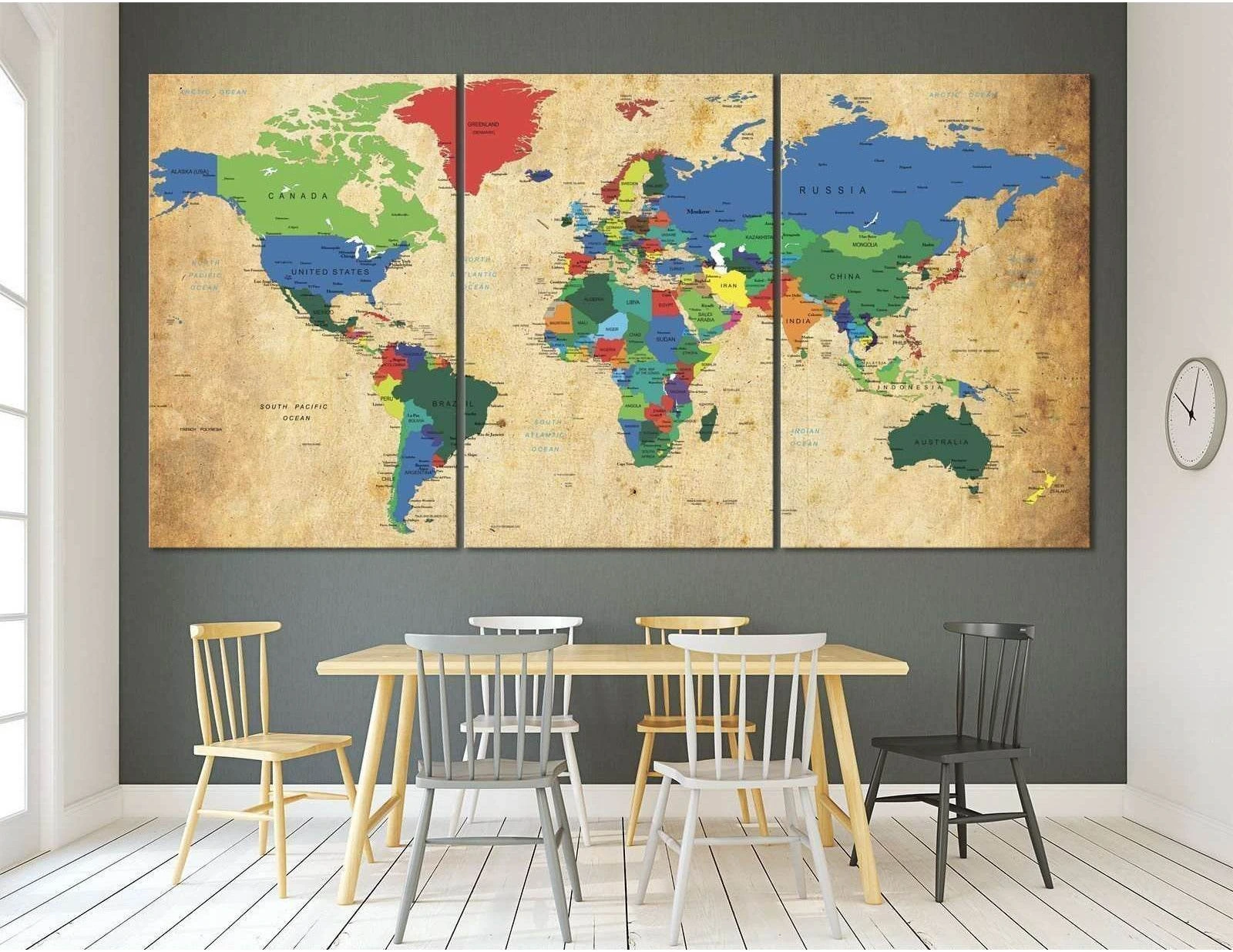 Vintage world map triptych canvas print above a dining table in a modern dining room