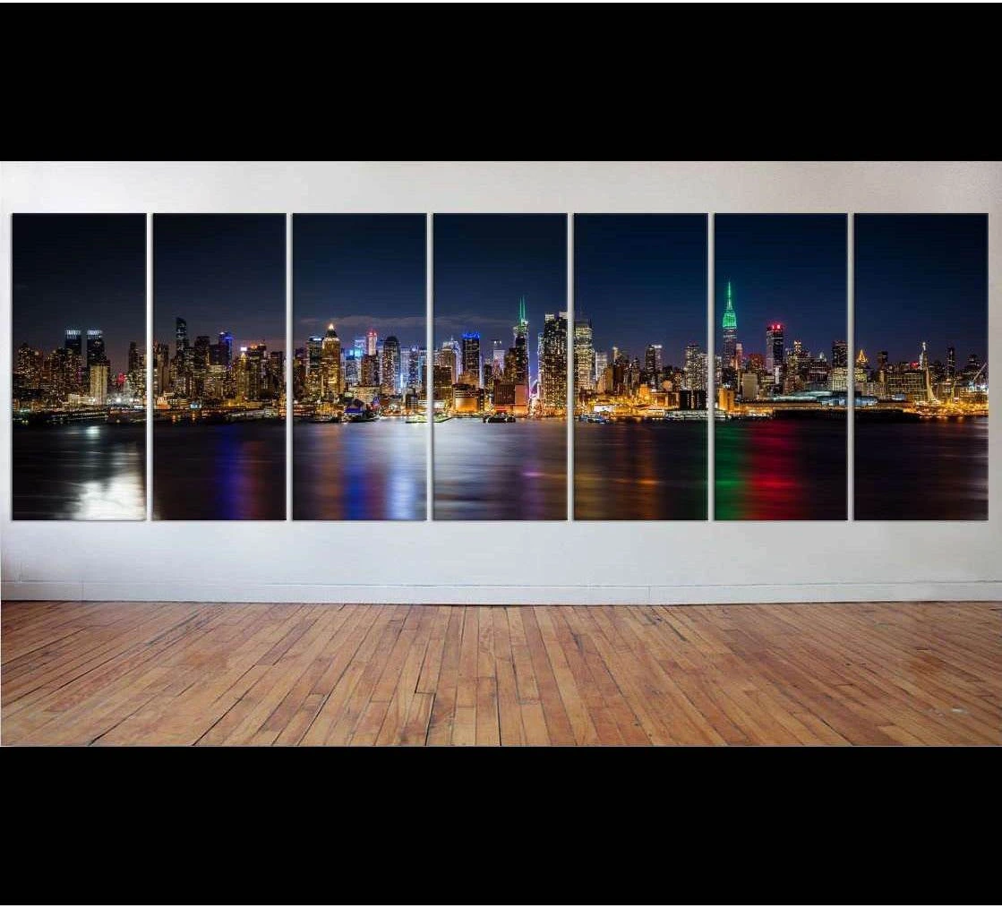 Seven-panel NYC skyline canvas print at night with Manhattan lights reflected across the water