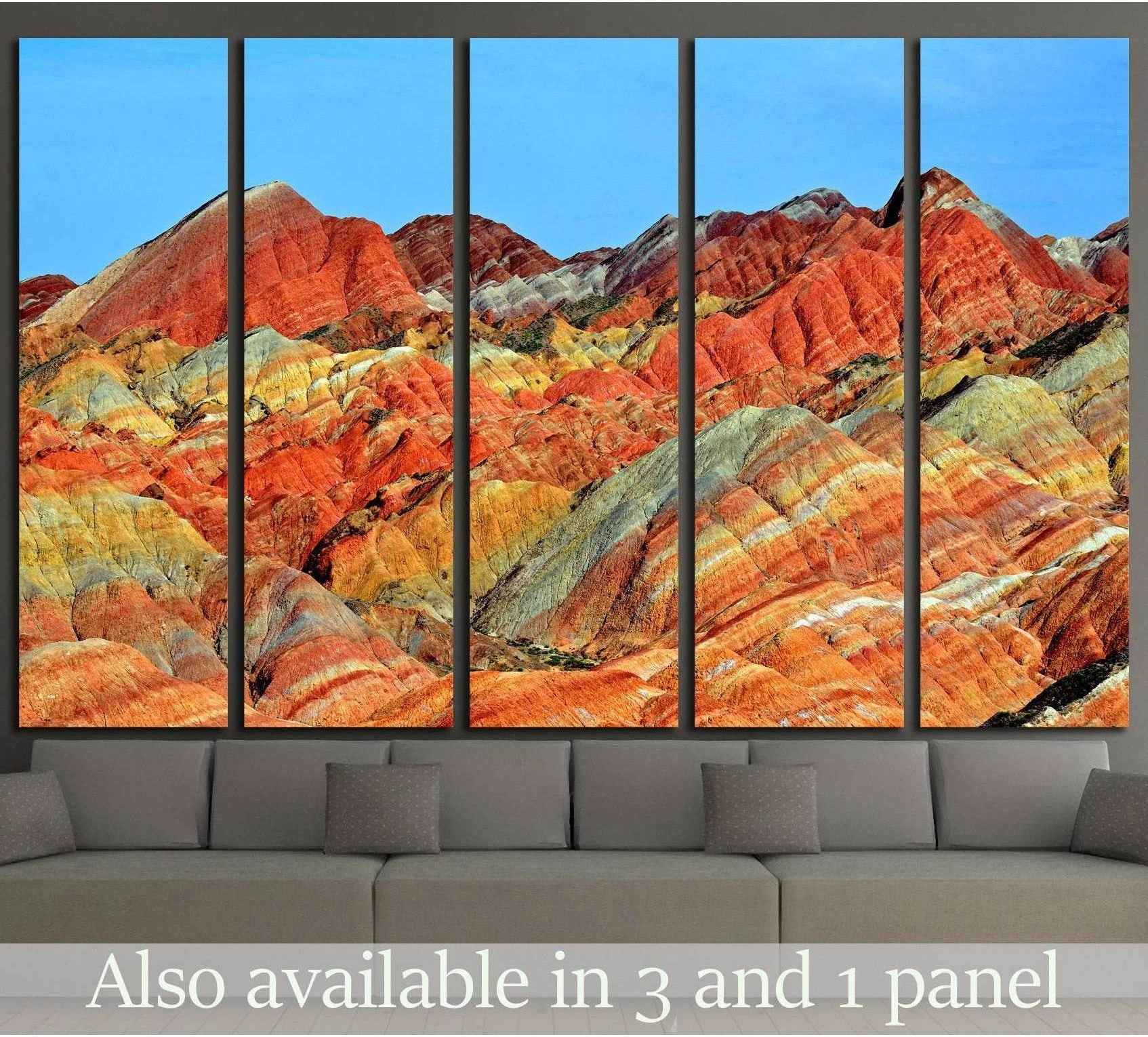 Zhangye Danxia rainbow mountains canvas print in warm red, orange, and gold bands above a gray sofa